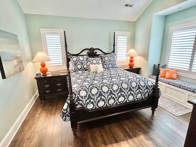 bedroom with wood-type flooring, multiple windows, and vaulted ceiling
