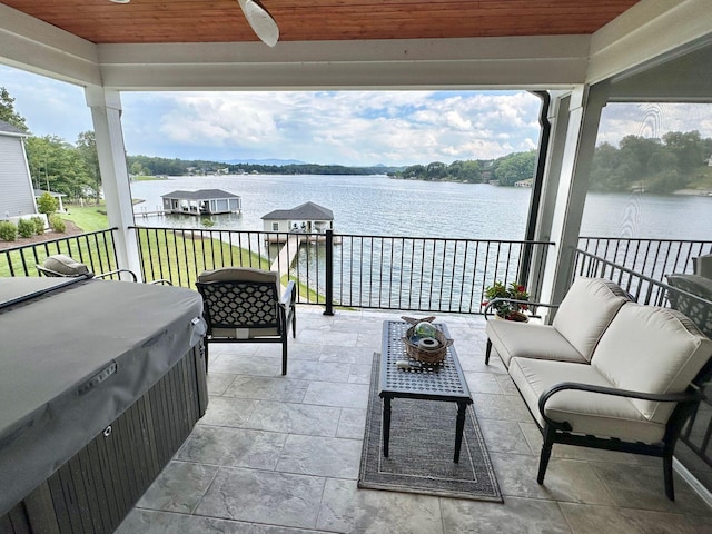 view of patio featuring an outdoor living space, ceiling fan, a water view, and a hot tub