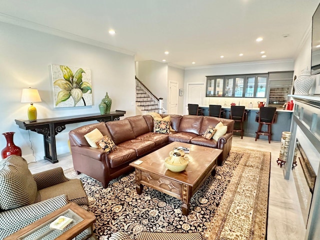 living room with a stone fireplace and crown molding