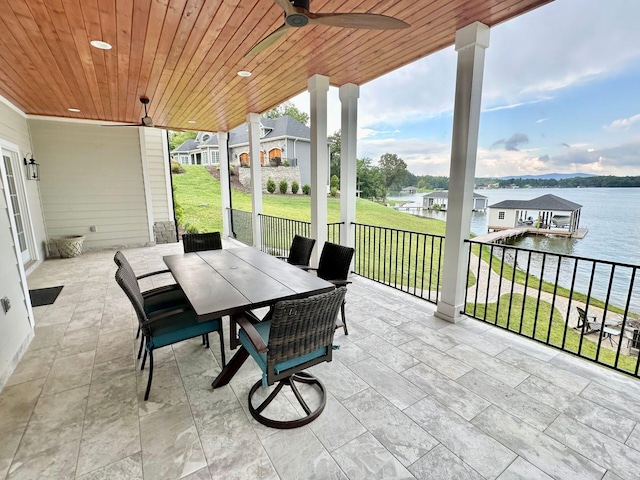 view of patio with a water view and ceiling fan