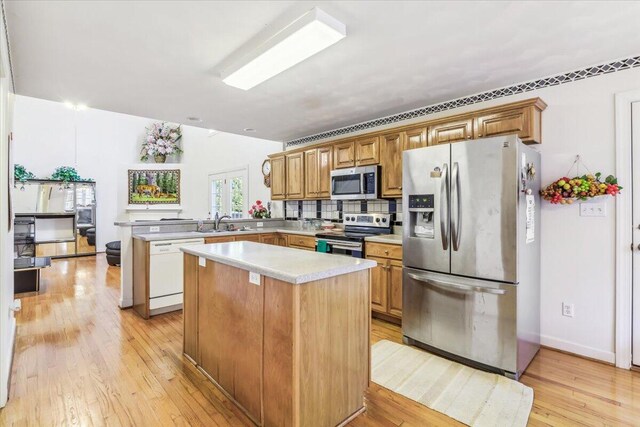 kitchen with a kitchen island, light hardwood / wood-style flooring, pendant lighting, and an inviting chandelier