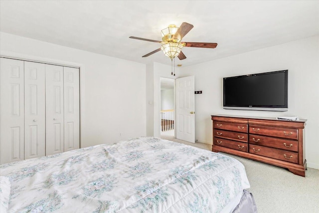 bedroom with a closet, ceiling fan, and light colored carpet