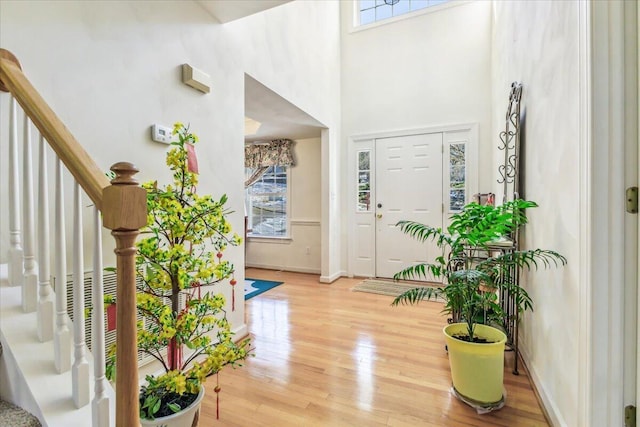 foyer entrance with hardwood / wood-style flooring and a towering ceiling