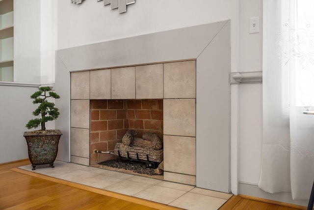 details with hardwood / wood-style floors and a tiled fireplace