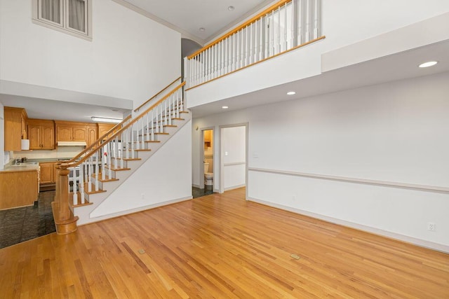 unfurnished living room featuring a high ceiling and light wood-type flooring