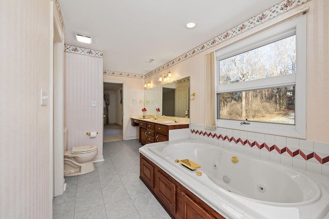 bathroom with tile patterned floors, toilet, vanity, and a bath