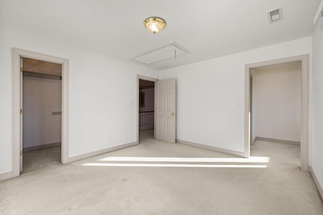 unfurnished bedroom with a closet, light colored carpet, and a spacious closet