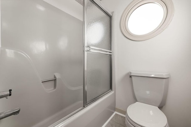 bathroom with toilet, enclosed tub / shower combo, and tile patterned floors