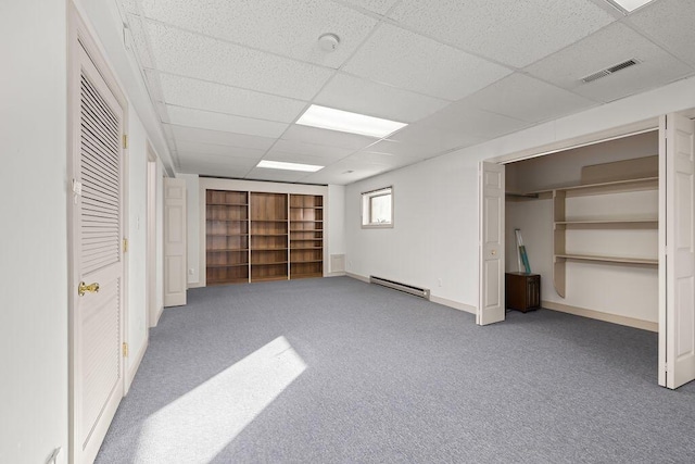 basement with carpet floors, a baseboard heating unit, and a paneled ceiling