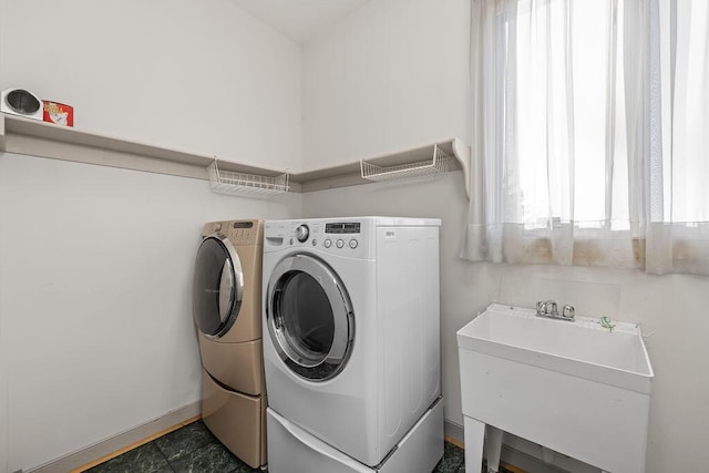 clothes washing area featuring sink and separate washer and dryer