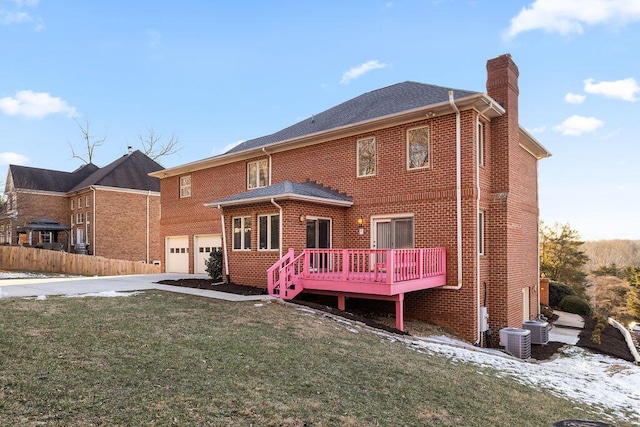 back of house with a lawn, a garage, a wooden deck, and central AC