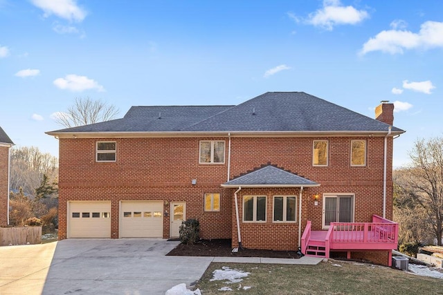 back of house with a garage, a deck, and central air condition unit