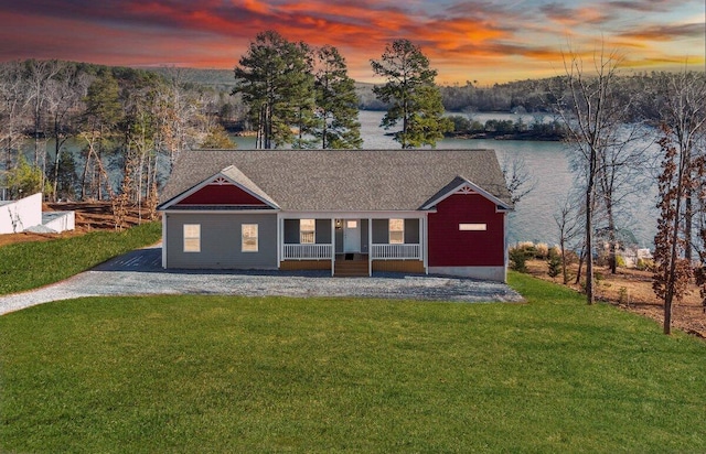 ranch-style house featuring a yard, a water view, and a porch