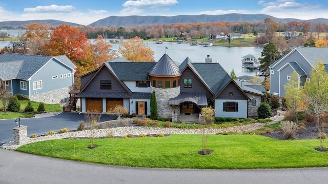 view of front of home with a front yard and a water and mountain view