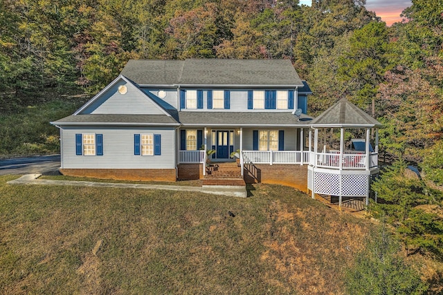 view of front of house featuring covered porch and a lawn