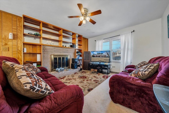 carpeted living room featuring a brick fireplace and ceiling fan