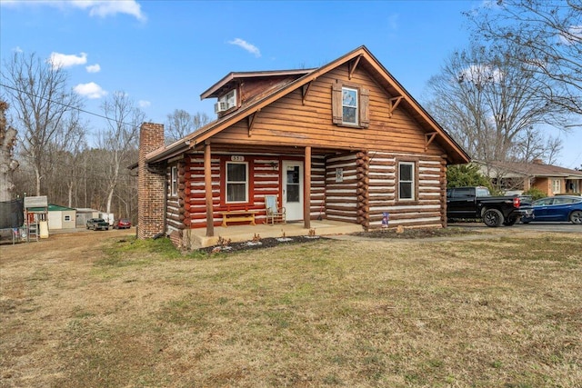 cabin featuring a front yard and a porch