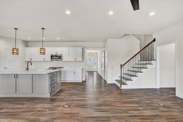 kitchen featuring stainless steel microwave, light countertops, dark wood-style floors, white cabinets, and recessed lighting