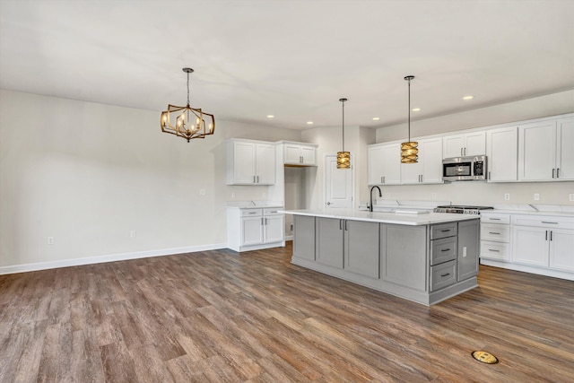 kitchen with stainless steel microwave, dark wood-style floors, recessed lighting, light countertops, and baseboards