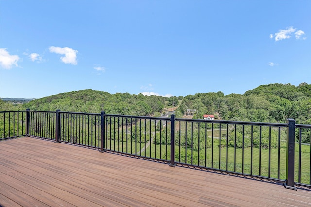 wooden terrace featuring a forest view