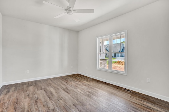 spare room with wood finished floors, baseboards, and ceiling fan