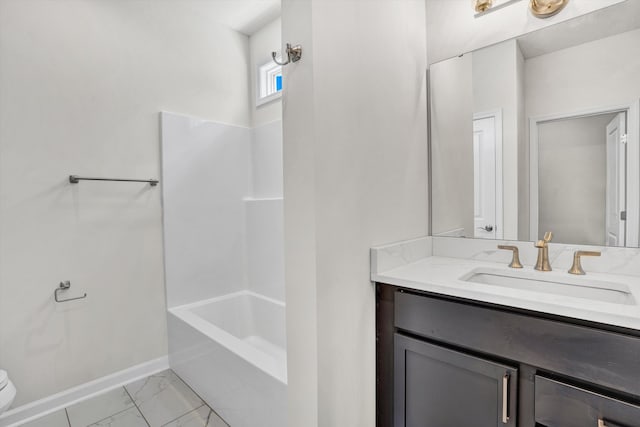 bathroom featuring vanity, marble finish flooring, toilet, baseboards, and bathtub / shower combination