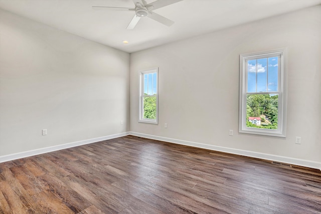 unfurnished room with dark wood-style floors, baseboards, and a ceiling fan