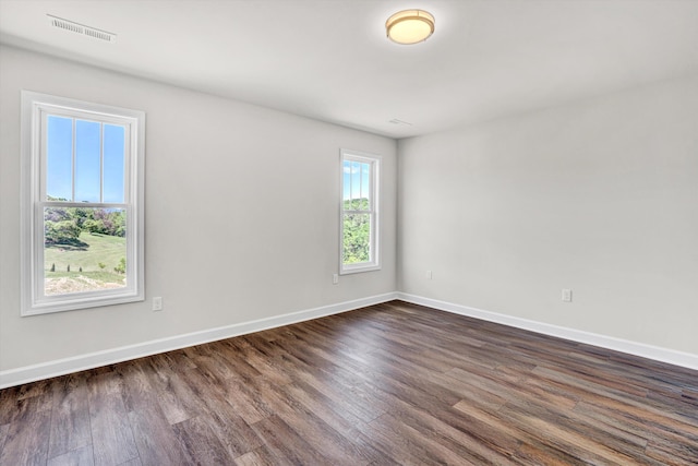 unfurnished room with dark wood-style floors and baseboards