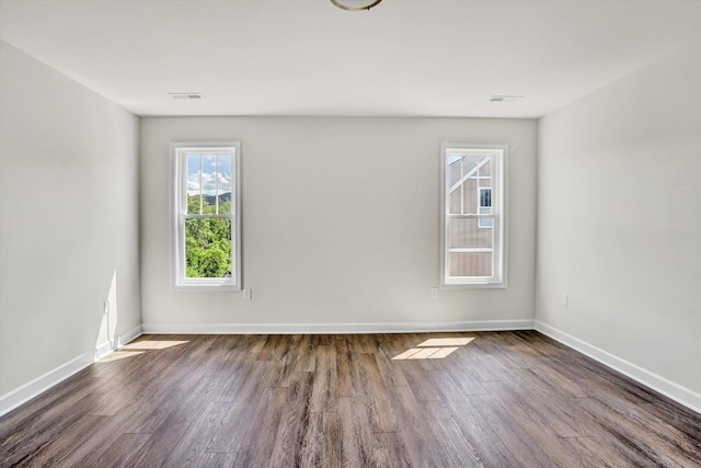 spare room featuring wood finished floors and baseboards
