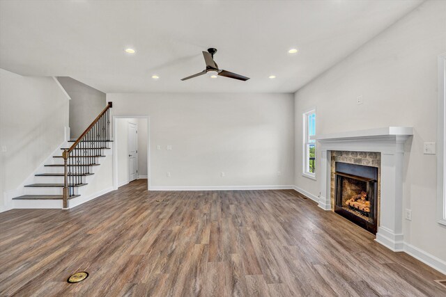 unfurnished living room featuring ceiling fan, stairs, wood finished floors, a fireplace, and recessed lighting