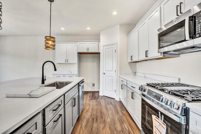 kitchen featuring stainless steel appliances, a sink, dark wood-style floors, white cabinets, and recessed lighting