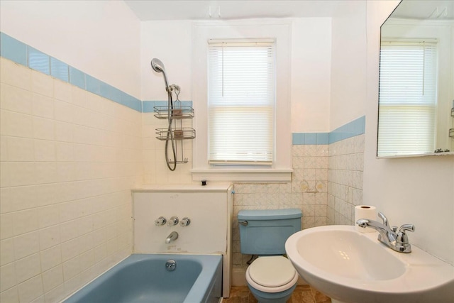 bathroom featuring sink, a bath, and toilet