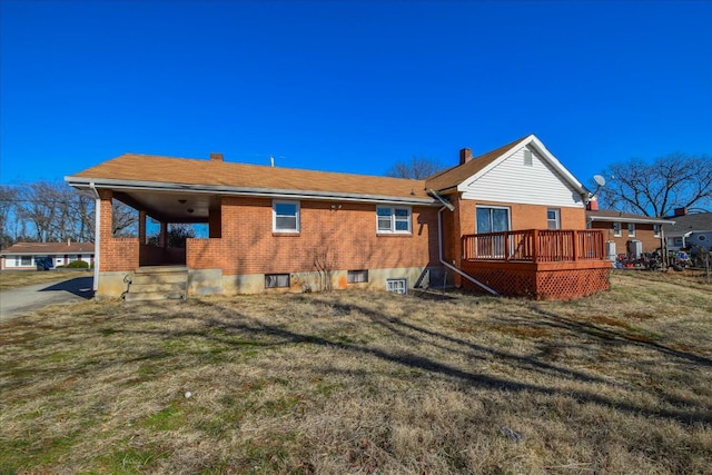 rear view of house with a wooden deck and a lawn