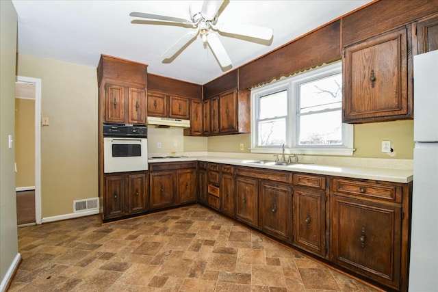 kitchen with sink, white appliances, and ceiling fan