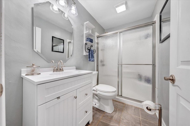 bathroom featuring vanity, toilet, and a shower with door