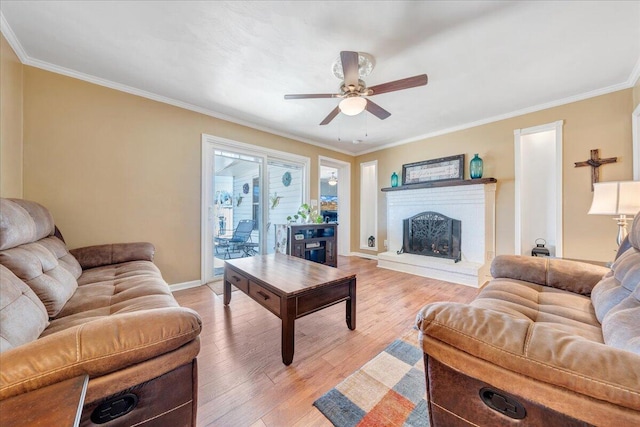 living room with crown molding, ceiling fan, and light wood-type flooring