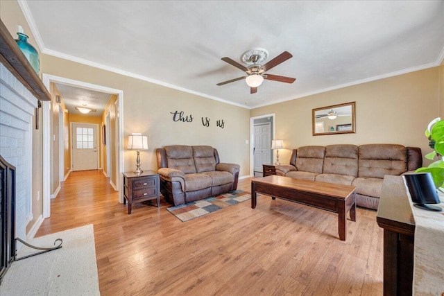 living room with ornamental molding, hardwood / wood-style floors, ceiling fan, and a fireplace