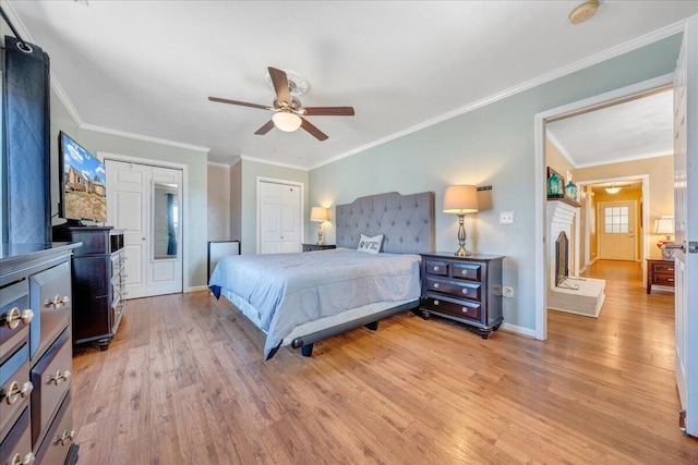 bedroom with crown molding, light wood-type flooring, ceiling fan, and a closet