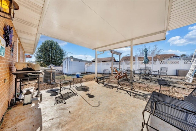 view of patio featuring a grill and a storage unit