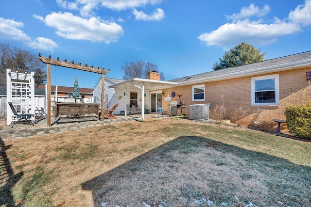 back of house with cooling unit, a yard, and a patio