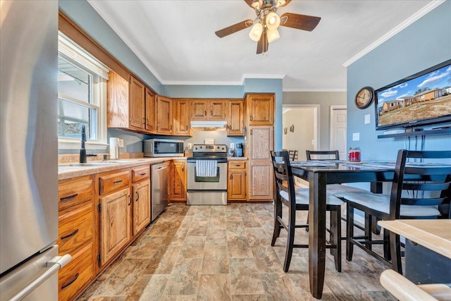 kitchen featuring stainless steel appliances, crown molding, sink, and ceiling fan