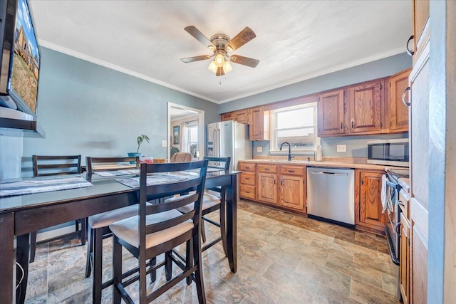 kitchen featuring sink, ornamental molding, stainless steel appliances, and ceiling fan