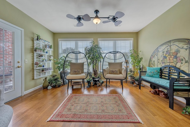 living area with ceiling fan, plenty of natural light, and light hardwood / wood-style flooring