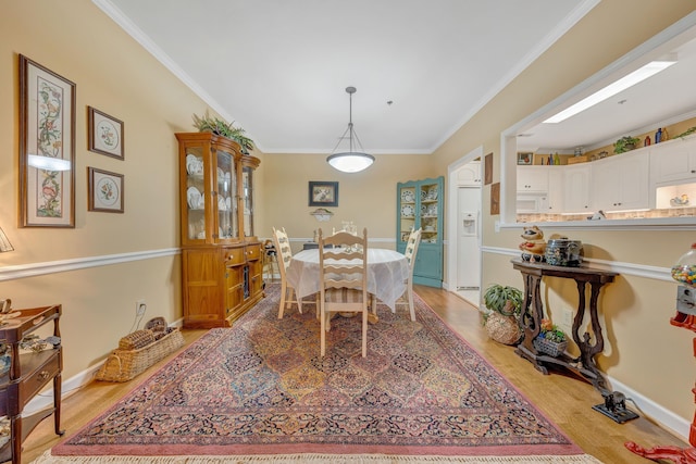 dining area with crown molding and light wood-type flooring