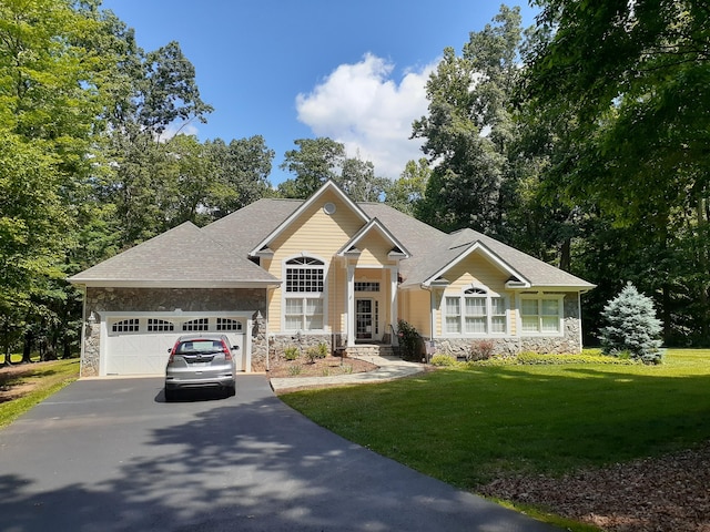 view of front of house with a front lawn, stone siding, driveway, and an attached garage