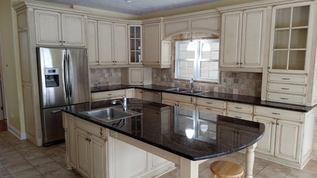 kitchen featuring cream cabinetry, stainless steel appliances, and a sink