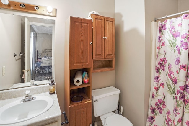 bathroom with vanity, curtained shower, and toilet