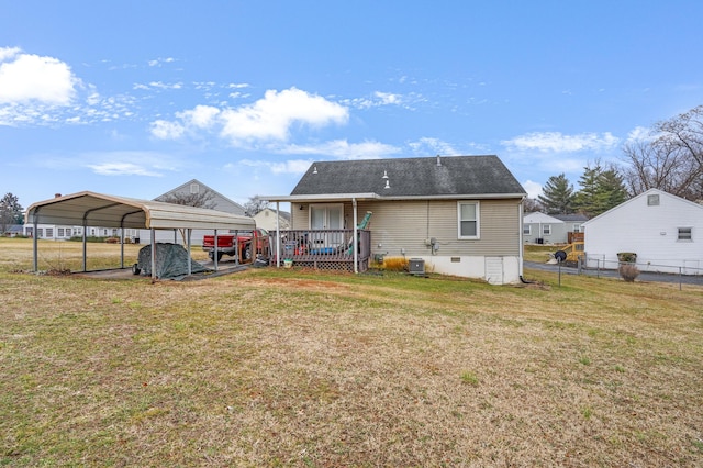 rear view of house featuring a carport, a wooden deck, central air condition unit, and a lawn