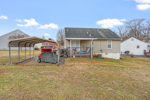 back of property with a carport, central AC unit, and a lawn