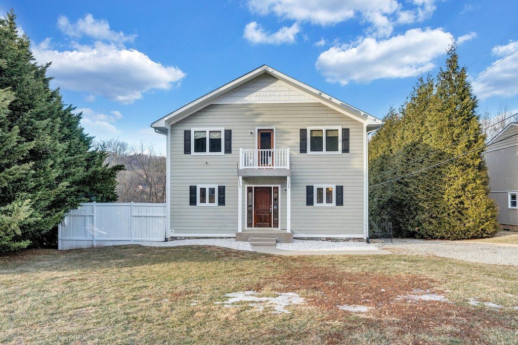 view of front property with a balcony and a front lawn